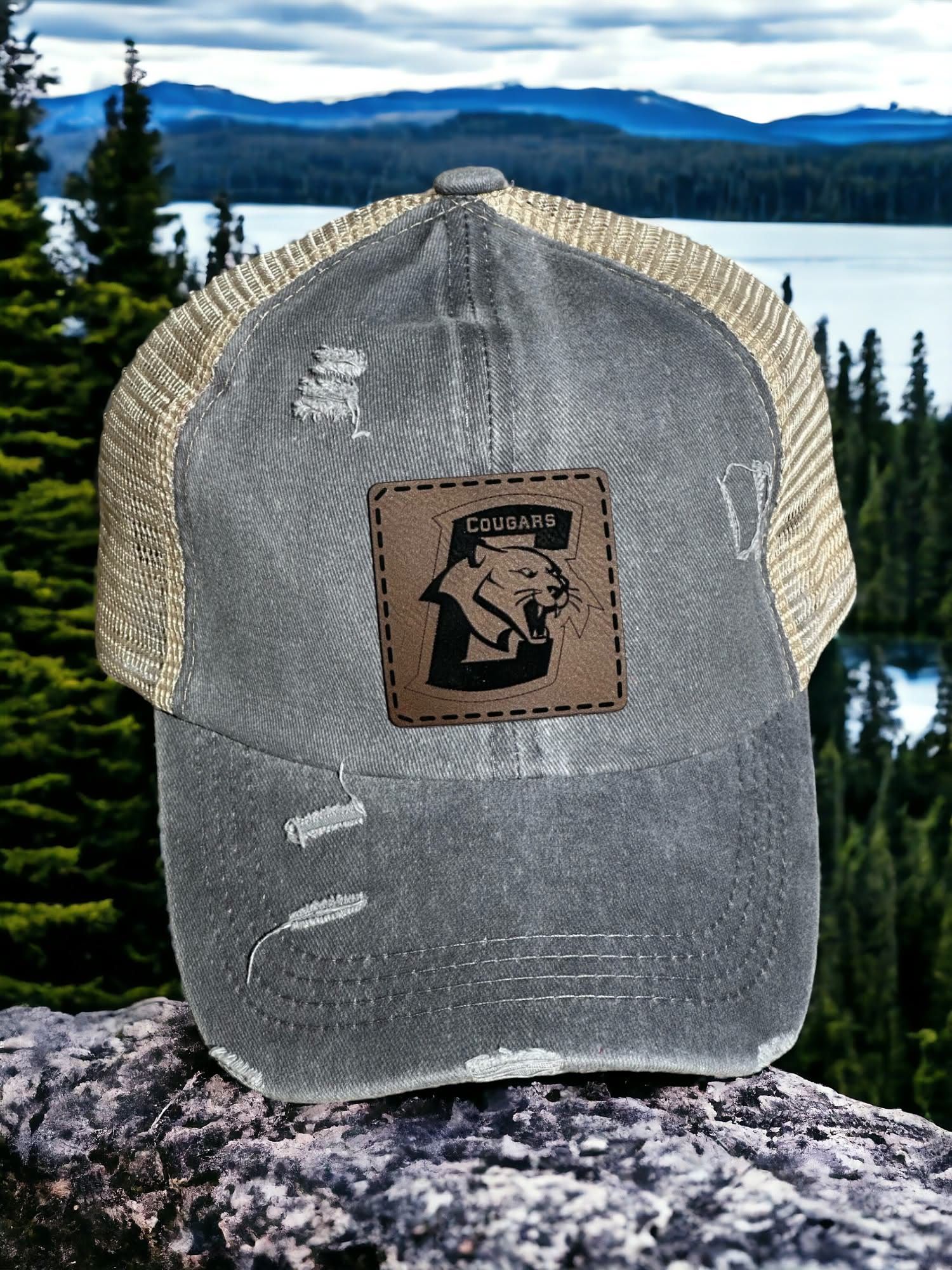 Distressed grey ponytail hat with a square leatherette Conestoga Cougars patch