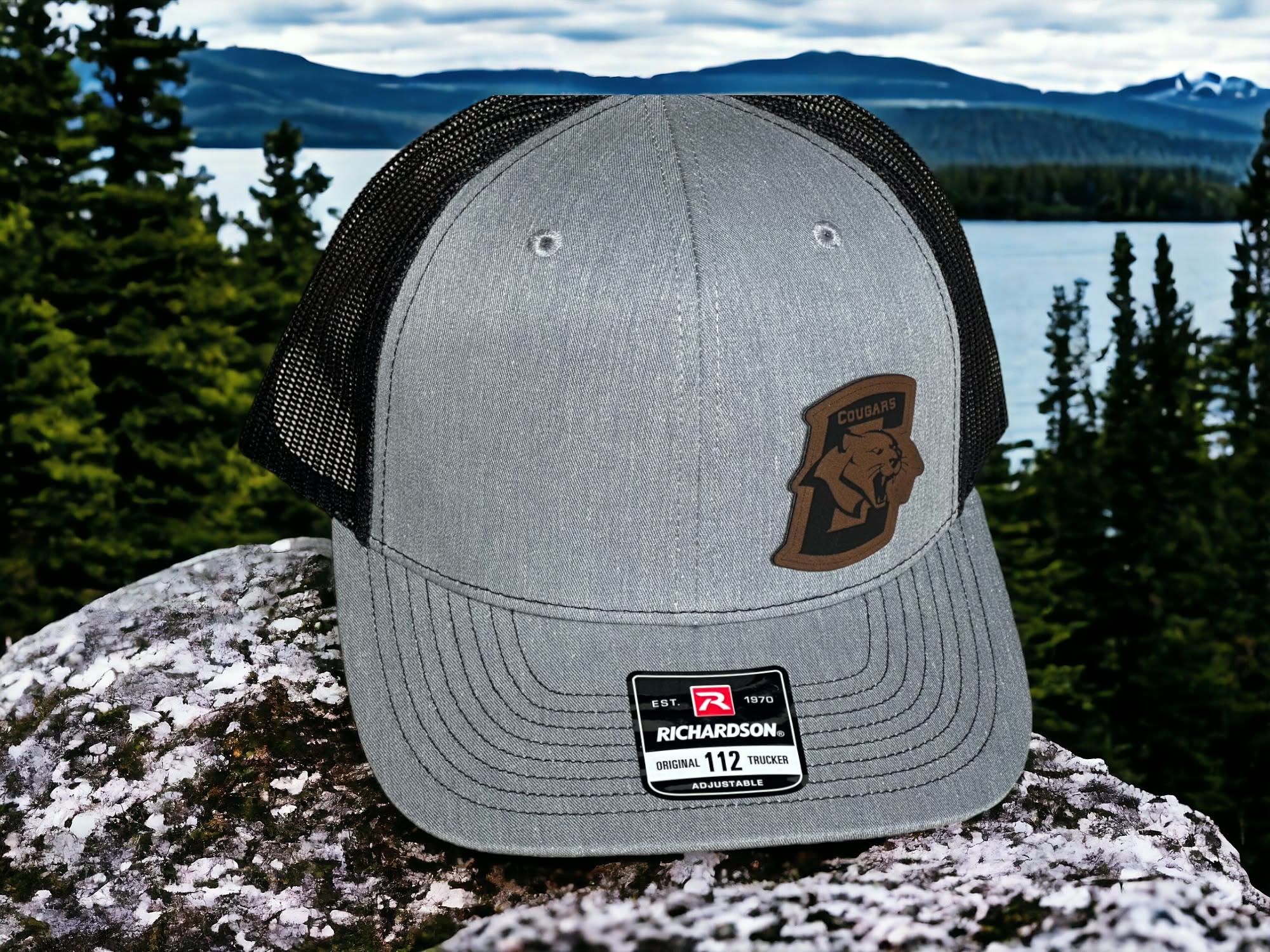Heather grey and black Richardson 112 with a shaped leatherette Conestoga Cougars patch