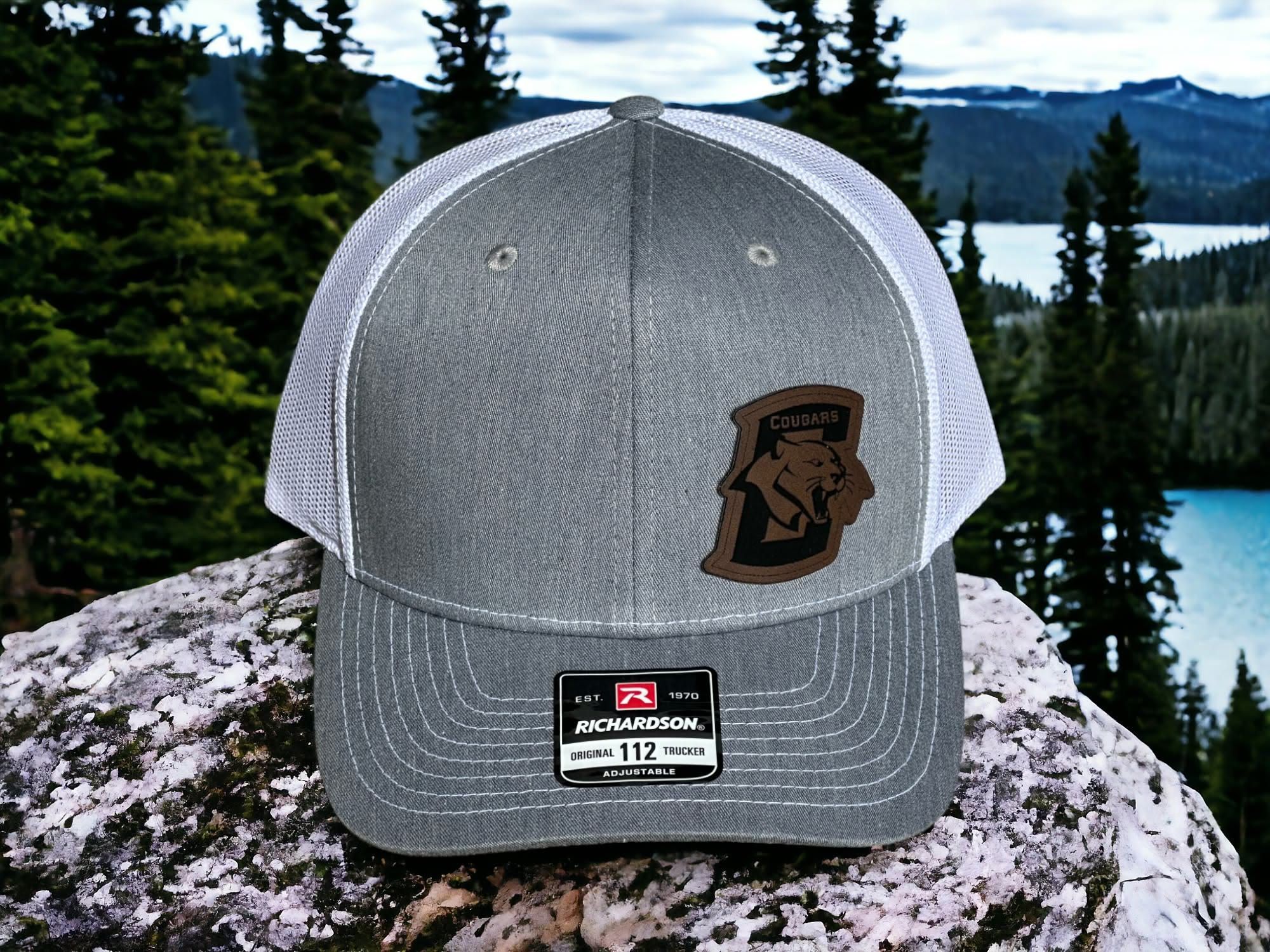 Heather grey and white Richardson 112 with a shaped leatherette Conestoga Cougars patch