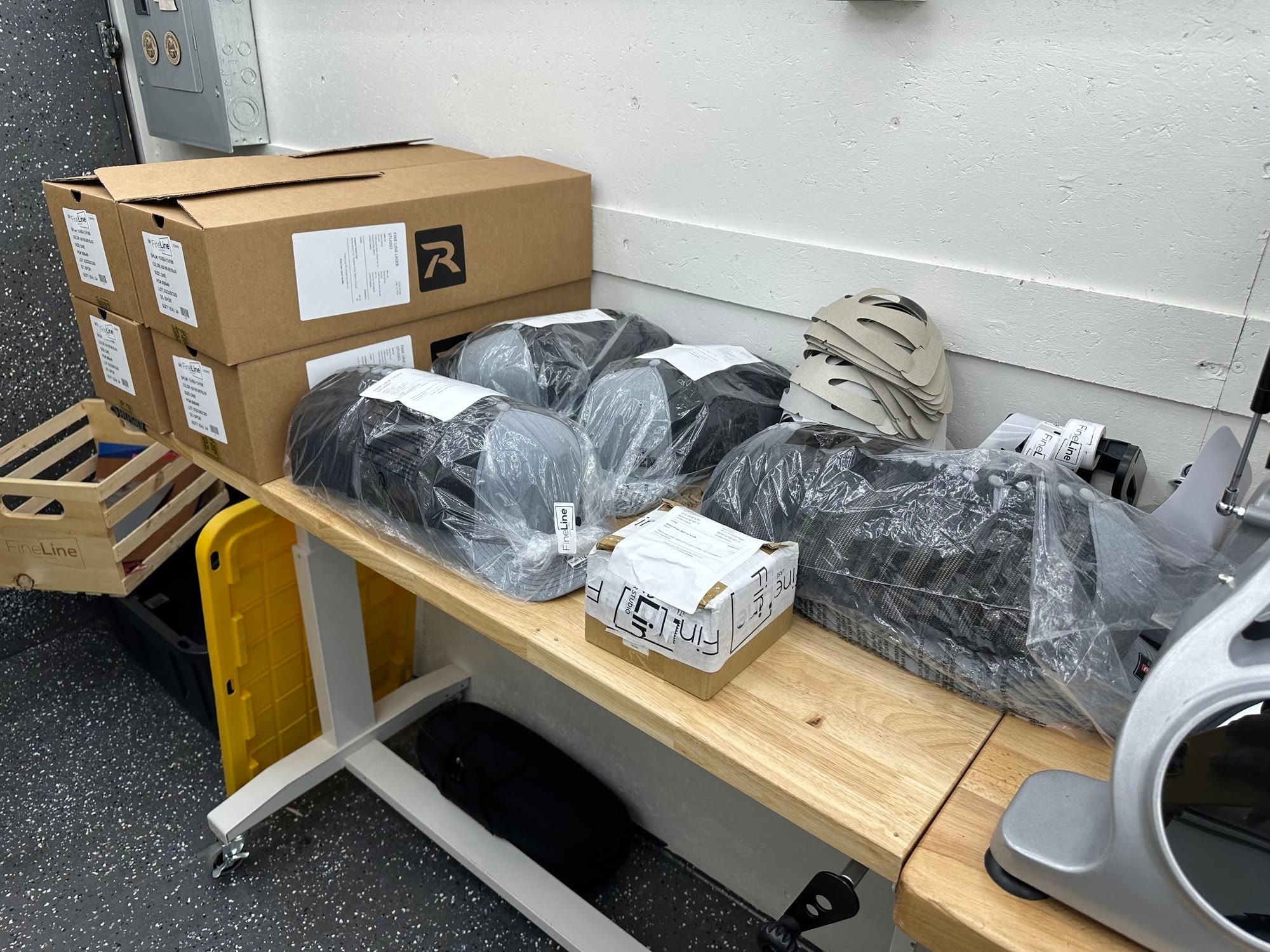 Boxed and bagged hat orders on a shop bench, ready to ship