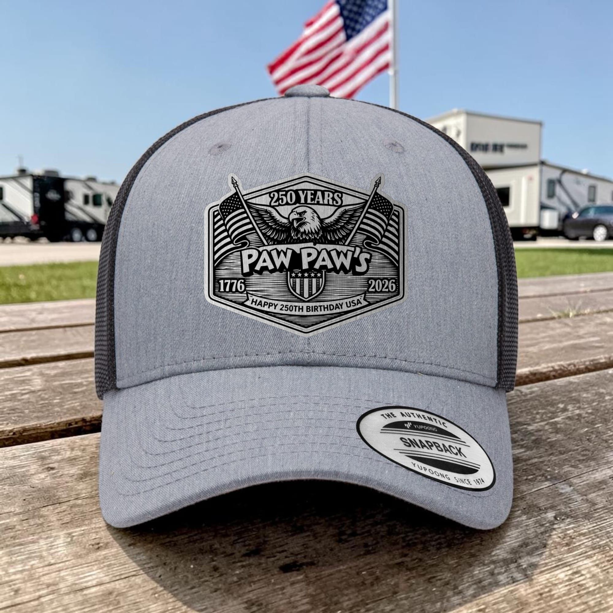 Heather grey snapback with a brushed-silver Paw Paw's 250 Years eagle-and-flags patch, American flag behind