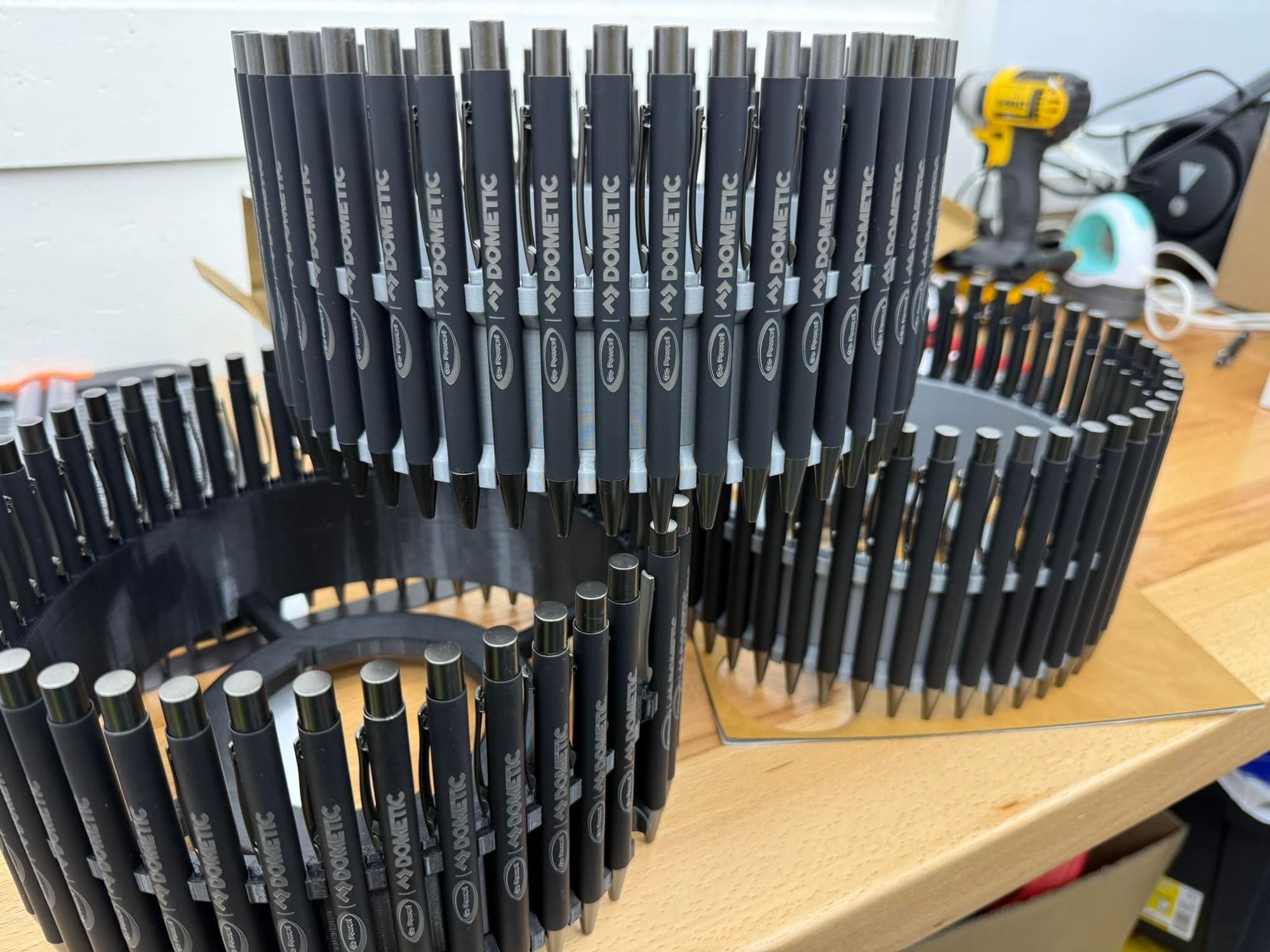 Hundreds of engraved Dometic pens loaded in a 3D-printed rotary jig